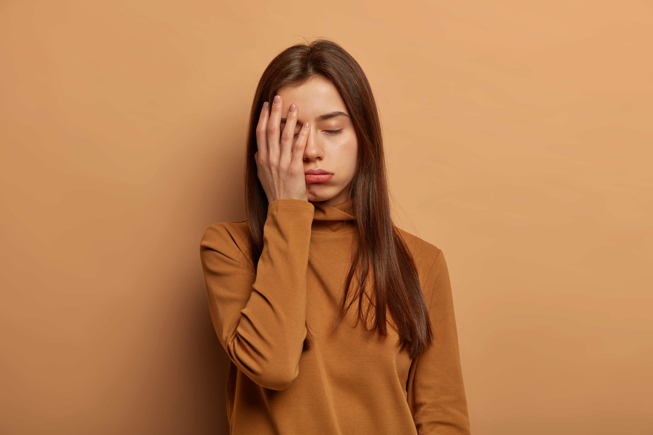 Woman holding her head with fatigue, illustrating hormonal imbalance for the Fertility Reset Blueprint.