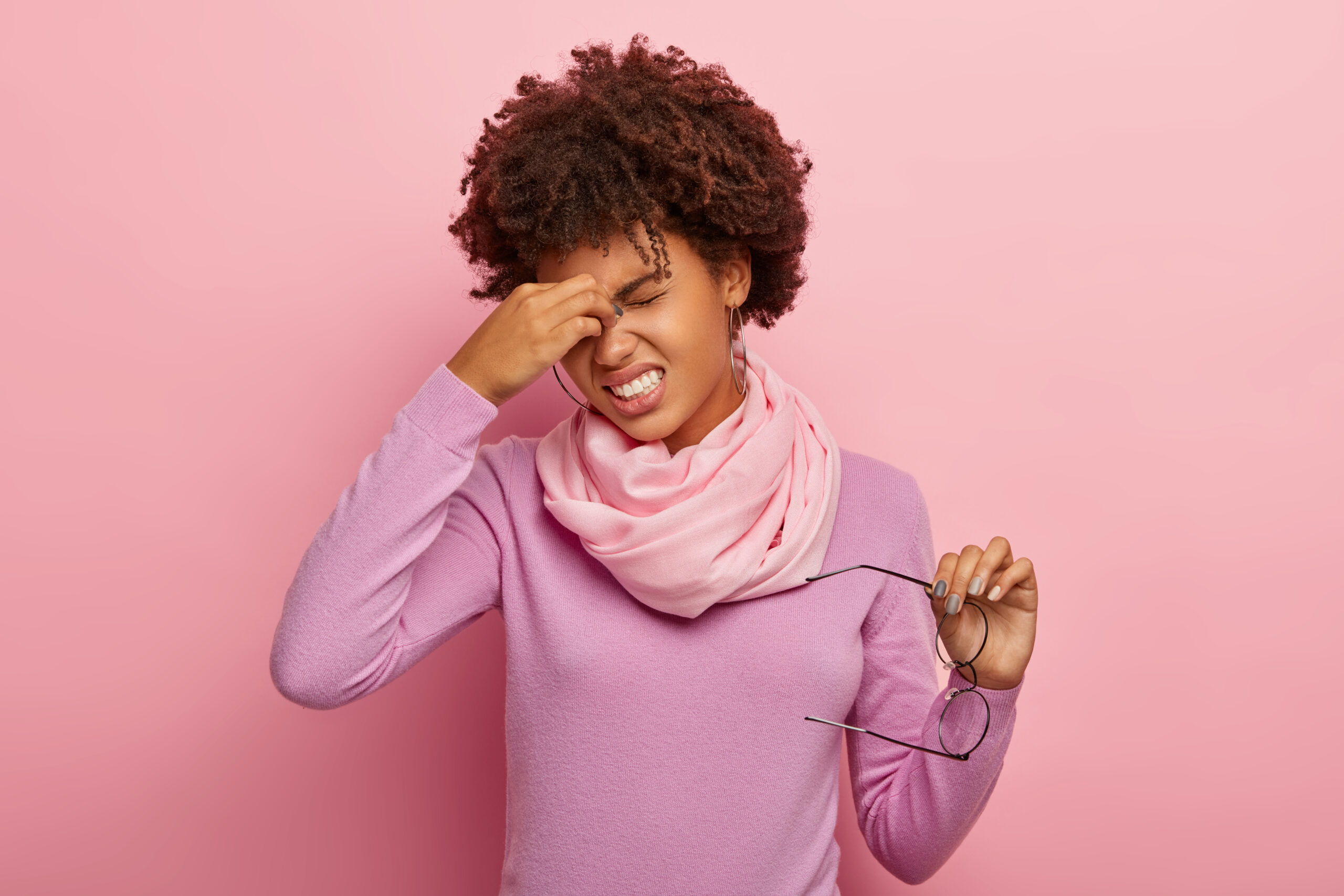 Woman touching her face with discomfort, representing hormonal symptoms addressed in the Fertility Reset Blueprint.